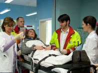 In aller Freundschaft – Jana Kraft (Marie Rönnebeck, liegend) wird nach einem Autounfall von den Notärzten (Komparsen) in die Sachsenklinik gebracht. Dort werden sie von Dr. Elena Eichhorn (Cheryl Shepard, rechts) und Schwester Yvonne (Maren Gilzer) in Empfang genommen.