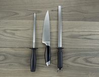 We love Cooking – Photo of single large kitchen knife and two sharpeners on aged white ash wood
