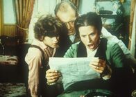 Unsere kleine Farm – Willie (Jonathan Gilbert, l.), Mr. Oleson (Richard Bull, M.) und Mrs. Oleson (Katherine MacGregor, r.) sind entsetzt über einen Bericht in der Zeitung.