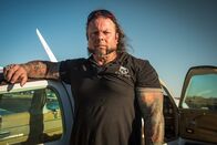 Airplane Repo - Die Inkasso-Piloten – Danny Thompson standing next to a car.