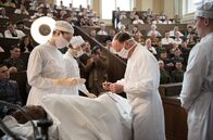 Charité – Die Wochenschau filmt: Prof. Sauerbruch (Ulrich Noethen, 2.v.r.) operiert den Oberschenkel von Lohmann (Ludwig Simon), assistiert von seiner Frau Margot (Luise Wolfram, l.), Schwester Christel (Frida-Lovisa Hamann, 2.v.l.) und Pfleger Martin Gruber (Jacob Matschenz, r.).