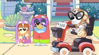 Bluey – Muffin spielt auf einem Flohmarkt die mürrische Oma und lässt sich von ihrem Vater auf einem alten Elektroroller schieben