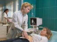 In aller Freundschaft – ", Regie: Peter Wekwerth Uhr im Ersten. Jutta Müller (Tatjana Blacher, re.) ist nach dem Lauftraining zusammengebrochen und lässt sich nun auf Drängen ihres Sohnes Holger in der Sachsenklinik von Dr. Kathrin Globisch (Andrea Kathrin Loewig, li.) untersuchen.