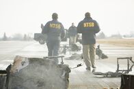 Mayday - Alarm im Cockpit – REENACTMENT - NTSB-Ermittler, Tom Haueter (gespielt von Christian Lloyd) und seine Crew begutachten die Absturzstelle am Quincy Regional Airport. (Cineflix International Media/Ian Watson)