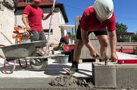 Handwerkskunst! – Maurermeister Erik Zedler aus Dexheim bei Hausbau in Gimbsheim in Rheinhessen. Erik Zedler setzt die erste Schicht Bimssteine in Mörtel, darunter Bitumenbahn als Feuchtigkeitssperre.