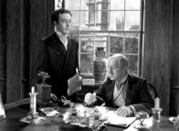 Adel verpflichtet – Louis Mazzini (Dennis Price, li.) arbeitet für den liebenswürdigen Bankier (Alec Guiness), einer der wenigen aus der Familie, die eines natürlichen Todes sterben.