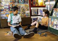 Young Sheldon – Sheldon (Iain Armitage, r.) wird von Tam (Ryan Phuong, l.) in die Welt der Comic geführt und scheint sogar Gefallen an den "Bilderbüchern" zu finden ...