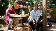 Der Lehrer – v.l.) singt ein Lied. Barbara (Nadine Wrietz), Stefan (Hendrik Duryn, r.) und Rose (Ulrich Gebauer) hören ihm zu während weitere Gäste eintreffen. +++ Die Verwendung des sendungsbezogenen Materials ist nur mit dem Hinweis und Verlinkung auf TVNOW gestattet. +++