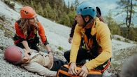 Die Bergretter – Tanja Rahner (Dominique Chiout, liegend) ist schwer verletzt. Für die Bergretter Katharina (Luise Bähr, l.) und Markus (Sebastian Ströbel) zählt jede Sekunde.