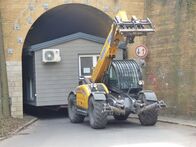 Terra Xpress – Bagger im Vordergrund zieht Containerhaus aus Tunnel.