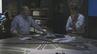 Mayday - Alarm im Cockpit – REENACTMENT - Lead NTSB Investigator Joe Sedor (played by Jason Faulkner) and second NTSB Investigator Evan Byrne (played by Darrin Baker) review photo evidence and taxi route on runway model and look shocked at what they just heard from the CVR of Comair Flight 5191. (Cineflix 2020/James Griffith)