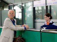 In aller Freundschaft – Gerade als Otto (Rolf Becker) seinen Flug umbuchen will, macht ihn die Dame am Airlineschalter (Julia Becker) darauf aufmerksam, dass gerade eine Durchsage zu hören ist, die wohl ihm gilt. Otto erkennt Charlottes Stimme, die ihm über die Lautsprecher einen Heiratsantrag macht.