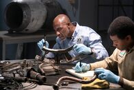 Mayday - Alarm im Cockpit – Investigator Dennis Jones (played by Glen Michael Grant) works hard to find any clues that can be gleaned from the wreckage of LAM Mozambique Flight 470, while the Lead Namibian Investigator (played by Jamaal Grant) takes notes. (Cineflix/Pana Pantazidis)