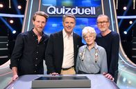 Quizduell – Moderator, l.) - Team „Vater-Sohn-Gespann““ - sowie der Teamkapitänin Team Deutschland Ilona Rebmann (75, Rentnerin aus Hamburg, 2.v.r.)