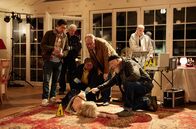 Rentnercops – "Mrs. Butterfly" (Komparsin) stirbt beim Krimi-Dinner. Dr. Lara Krüger (Dela Dabulamanzi, M.) entdeckt bei der Toten ein sehr großes Pflaster und tippt auf Gift (mit Aaron Lee, l., Hartmut Volle, 2.v.l. und Bill Mockridge, r.).