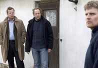 Mankells Wallander – Kommissar Kurt Wallander (Krister Henriksson, links) und sein Kollege Martinsson (Douglas Johansson, Mitte) verdächtigen den Schul-Hausmeister (Stefan Gödicke).