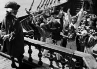 Die Schatzinsel – Die Hispaniola hat vor der Schatzinsel die Anker ausgeworfen. Kapitän Smollet (Jacques Monod, l.) gibt der Mannschaft Landurlaub.
