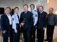 Mankells Wallander – Kommissar Wallander (Krister Henriksson, 3.v. links) feiert mit seinen Kollegen Svartman (Fredrik Gunnarson, 3.v. rechts), Nyberg (Mats Bergman, rechts) Ebba (Marianne Mörck, links) und Martinsson (Douglas Johansson, 2.v. rechts) das erfolgreich absolvierte Praktikum der jungen Polizeianwärter Isabell (Nina Zanjani) und Pontus (Sverrir Gudnason, 4.v. links).