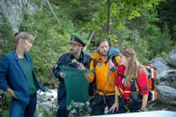 Die Bergretter – Die Kommissarin Jessika Pollath (Maxi Warwel, l.) bespricht mit Katharina (Luise Bähr, r.), Markus (Sebastian Ströbel, 2.v.r.) und Polizist Gert (Martin Leutgeb, 2.v.l.), wie es zu dem Unfall des Anglers kommen konnte.