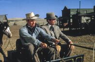Weites Land – Verwalter Steve Leech (Charlton Heston, li.) heißt James McKay (Gregory Peck, re.), einen Gentleman aus Baltimore und den zukünftigen Ehemann von Patricia Terrill, willkommen.