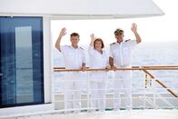 Das Traumschiff – Dr. Sander (Nick Wilder), Beatrice (Heide Keller) und Kapitän Burger (Sascha Hehn) stehen winkend an Deck der MS Amadea.