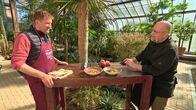 MarktFrisch – In einem der Gewächshäuser verkostet Frank Brunswig (re.) beide Gerichte und muss entscheiden, welches besser schmeckt. Links: "Kochschüler" Jens Hübschen.