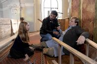 Der Bergdoktor – Marie (Rebecca Wanderer, l.) macht sich Sorgen um ihren Vater Markus (Michael A. Grimm, r.), der von der Leiter gefallen ist. Martin (Hans Sigl, M.) vermutet eine Rippenfraktur.