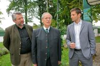 Die Rosenheim-Cops – Nachtportier Wiesinger (Wilfried Klaus, M.) hat heimlich Zimmer vermietet. Die Rosenheimer Ermittler Stadler (Dieter Fischer, l.) und Hansen (Igor Jeftić, r.) vermuten, dass er seine Chefin ermordet hat, nachdem diese von den Machenschaften erfahren hat.