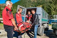 Der Bergdoktor – Mithilfe der Bergrettung kann Dr. Martin Gruber (Hans Sigl, r.) den kollabierten Arno Moosbach (Dominic Raacke, liegend) schnell in die Klinik bringen.