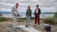 Mordufer – Gerichtsmediziner Gregor Eisen (Ronald Kukulies, l.) gibt den Kriminalkommissarinnen Doro Beitinger (Franziska Weisz, M.) und Chiara Locatelli (Maria Wördemann, r.) am Tatort am Ufer des Bodensees erste Informationen zum brisanten Todesfall.