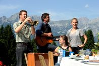 Der Bergdoktor – Hans (Heiko Ruprecht, l.), Martin (Hans Sigl, 2.v.l.), Lilli (Ronja Forcher, 2.v.r.) und Andrea (Tessa Mittelstaedt, r.) singen Lisbeth zu ihrem Geburtstag ein Ständchen.