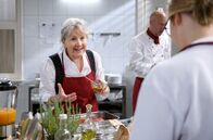 Sturm der Liebe – Hildegard (Antje Hagen, l.) unterhält sich beim Kochen mit Josie (Lena Conzendorf, r. mit Komparse) auch über private Dinge.