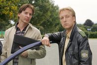 Die Rosenheim-Cops – Der Fall bekommt eine Wendung, als Polizist Mohr (Max Müller, r.) von Florian Happach (Alexander Friedrich, l.) pikante Fotos erhält.