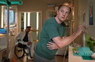 In aller Freundschaft – Dr. Ilay Demir (Tan Caglar, li.) erwischt den Patienten Holger Meyer (Steffen Will, re.) an einem Schrank im Schwesternzimmer. Doch Holger hat die Erlaubnis von Arzu Ritter, sich an ihrem privaten Keksvorrat bedienen zu dürfen.