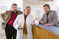 Die Rosenheim-Cops – Dr. Mertens (Fritz von Friedl, m.) macht sich bei den Kommissaren Sven Hansen (Igor Jeftic, r.) und Stadler (Dieter Fischer, l.) höchst verdächtig.