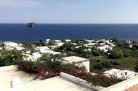 Leben mit Vulkanen – Blick über ein Dorf auf der italienischen Insel Stromboli, welche zum Archipel der Liparischen Inseln gehört