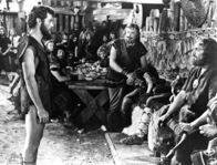 Die Wikinger – Eric (Tony Curtis, li.) wächst als Sklave am Hofe der Wikinger auf. König Ragnar (Ernest Borgnine, re.) hat ihn als Baby aus England entführt.