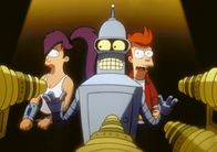 Futurama – Als Leela und Fry (r.) erfahren, dass Bender auf einem von Robotern bevölkertem Planeten in Schwierigkeiten geraten ist, eilen sie ihm schnell zu Hilfe. Doch das hat Folgen: Der Ältestenrat der Roboter verurteilt alle drei zur Todestrafe.