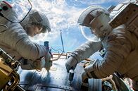 Gravity – Die Astronautin Ryan Stone (Sandra Bullock) wird von Matt Kowalski (George Clooney) bei ihren Reparaturarbeiten am Weltraumteleskop „Hubble“ unterstützt.