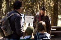 2012 – Durch Zufall treffen Jackson Curtis (John Cusack, l.), seine Tochter Lilly (Morgan Lily, 2.v.l.) und sein Sohn Noah (Liam James, 2.v.r.) auf den exzentrischen Einsiedler Charlie Frost (Woody Harrelson, r.).