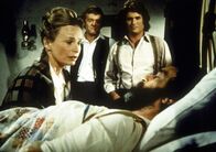 Unsere kleine Farm – Grace Edwards (Bonnie Bartlett, l.) kniet am Krankenbett ihres Mannes Isaiah (Victor French). Dr. Baker (Kevin Hagen, M.) und Nachbar Charles Ingalls (Michael Landon, r.) stehen ihr zur Seite.