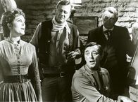 El Dorado – In El Dorado ist man nicht sehr begeistert, als ein alternder Revolverheld namens Cole Thornton (John Wayne, 2.v.l.) auftaucht. Er ist ein alter Freund von Sheriffs Harrah (Robert Mitchum, sitzend), aber er kam nicht, um Harrah zu besuchen. Rancher Kewan Mac Donald (R.G. Armstrong, r.) und seine Tochter Joe (Michele Carey, l.) haben Grund zur Skepsis.