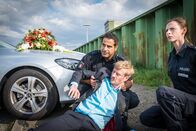 Notruf Hafenkante – Auf der Suche nach dem vermissten Onkel der Braut finden Tarik (Serhat Cokgezen, l.) und Kim (Carolyn Genzkow, r.) Theo Metzner (Eric Bouwer, M.) verletzt vor der Hochzeitslimousine.