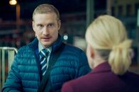 Zwei gegen die Bank – Auf der Zugfahrt nach Rom bringt der Schaffner (Michael Edlinger) Juliette (Caroline Peters) mit einer Frage nach ihrem Koffer in Verlegenheit.