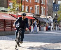 The Chelsea Detective – Max Arnold ( Adrian Scarborough) auf seinem Fahrrad in den Straßen von Chelsea unterwegs.