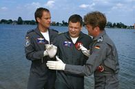 Die Rettungsflieger – Motorbootunfall am Baggersee: Ein kleines Mädchen wird noch vermisst und Thomas (Ulrich Bähnk, M.)befürchtet, dass es sich um seine kleine Tochter Nina handelt. Alex (Matthias Leja, l.) und Wollcke (Oliver Hörner, r.) haben große Mühe, ihn zu beruhigen.