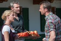 Der Bergdoktor – Hans (Heiko Ruprecht, r.) ist wütend, weil seine Tochter Sophia wegen eines Infekts nicht zu ihm kommen kann und sich Tim (Ben Braun, M.) nach seinem Geschmack zu viel einmischt. Susanne (Natalie O'Hara, l.) hat für sein Verhalten wenig Verständnis.