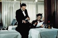 Brust oder Keule – Er kommt inkognito zu den Wirten, mal als Dame, Cowboy und Chauffeur verkleidet. Restaurant-Tester Charles Duchemin (Louis de Funès, r.) schnuppert, futtert, schluckt sich durch die Menüfolgen der von ihm unerbittlich kontrollierten Restaurants und drangsaliert damit die Kellner ...