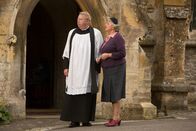 Father Brown – Die tödliche Kugel hat nicht Bischof Talbot getroffen, sondern Albert Davies. Nach dessen Beerdigung beratschlagen sich Mrs McCarthy (Sorcha Cusack, r.) und Father Brown (Mark Williams, l.).