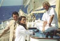 Unter weißen Segeln – Der Ägypter Yussuf (Oliver Tobias, li.) hat ein Auge auf Cruisedirektorin Marlene (Christine Neubauer) geworfen, was Kapitän Bernd Jensen (Horst Janson) beunruhigt.